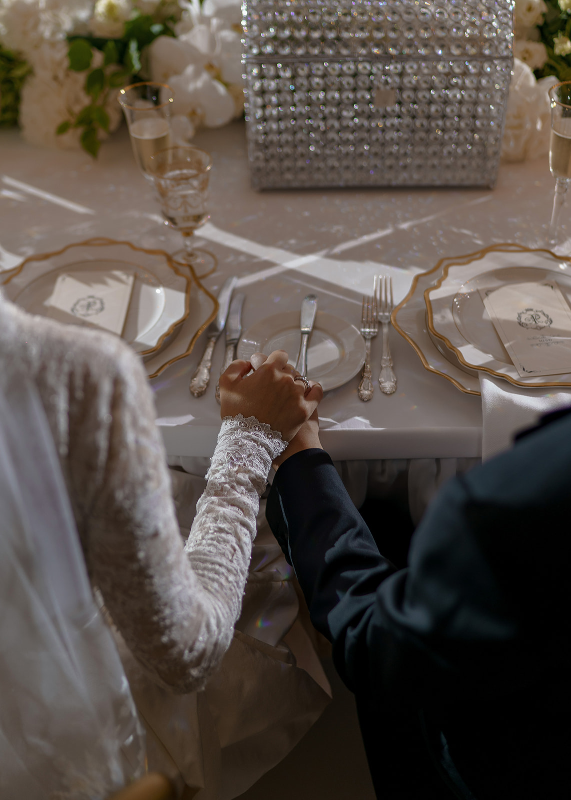 bride and groom holding hands at sweetheart table